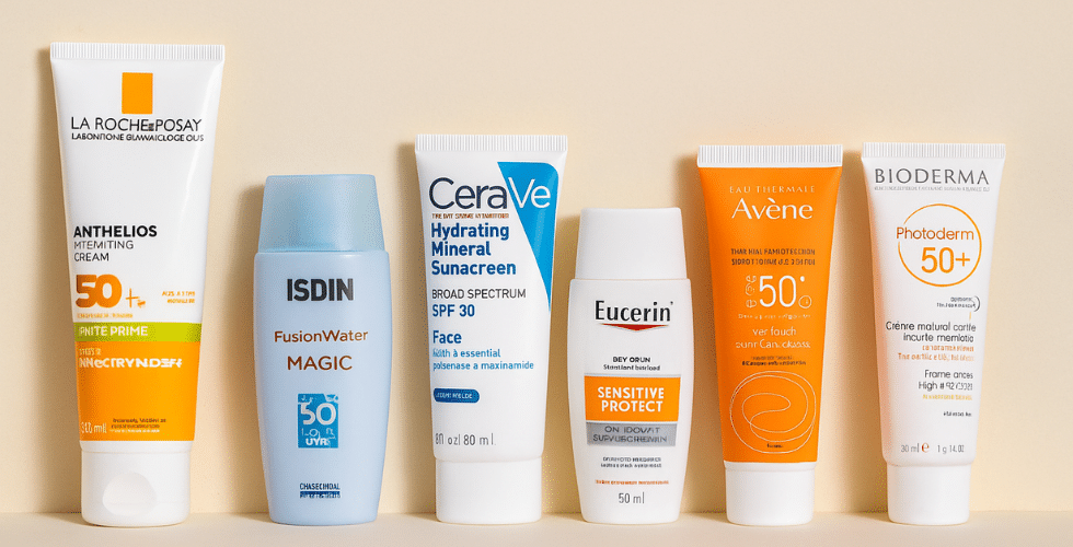 شش ضدآفتاب شامل La Roche-Posay، ISDIN Fusion Water، CeraVe، Eucerin، Avène و Bioderma در ردیفی منظم روی زمینه بژ چیده شده‌اند، با نور نرم و فاصله دورتر، مناسب برای پوست‌های خشک و حساس.